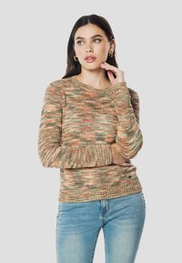 Kötött pulóver földszínekkel, narancs és zöld árnyalataiban, hosszú ujjakkal, bordázott mandzsettákkal és szegéllyel.