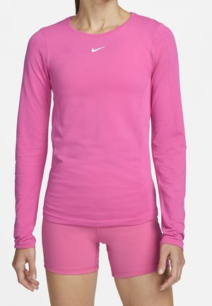 Haut de sport à manches longues et shorts assortis en rose vif. Fabriqué en matériau lisse et extensible avec un col rond et des détails de ventilation subtils.