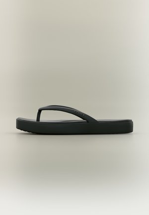 Sandale tongs en caoutchouc noir avec une semelle épaisse et une bride en forme de Y avec le logo Crocs sur un fond neutre.