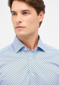 Camicia azzurra chiara con un piccolo motivo geometrico, colletto button-down e texture del tessuto liscia. La vista frontale mette in evidenza i dettagli del design.