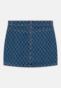 Jupe en denim avec un motif de logo bleu clair répété, base bleu foncé, deux poches arrière et des accents de couture visibles.