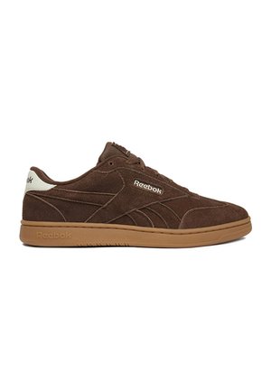 Zapatilla Reebok de ante marrón con suela beige y lengüeta blanca en el talón, vista desde un lateral sobre fondo blanco.