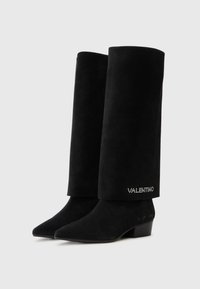 Bottes noires en daim montantes avec un bout pointu, un talon bas et un texte décoratif VALENTINO orné de strass.