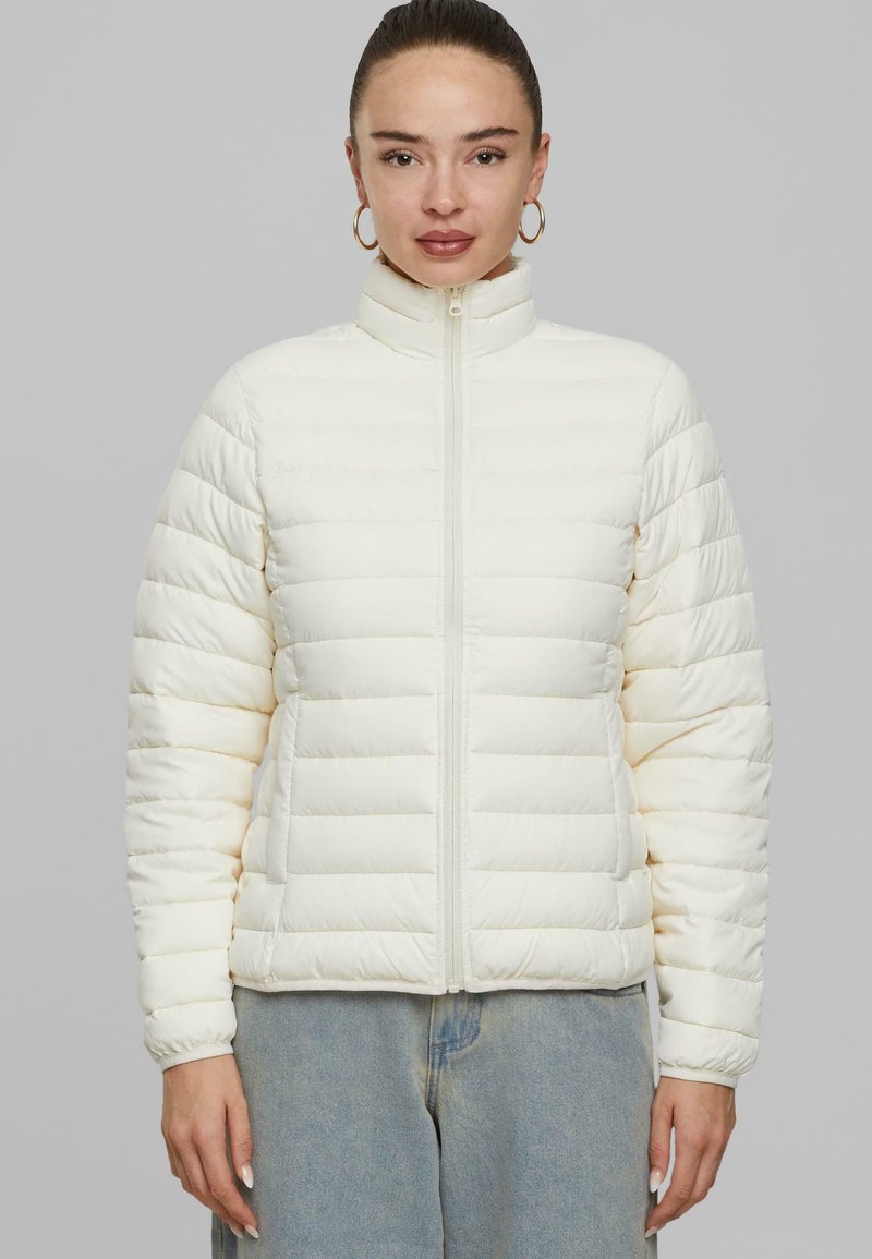 Doudoune blanche avec col haut, fermeture éclair à l'avant et poignets élastiques. Présente un design matelassé horizontal et une texture douce et lisse.