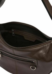 Brązowa skórzana torebka o gładkiej fakturze, z wewnętrzną kieszenią na zamek i metalowym zamkiem błyskawicznym. Posiada przeszywany wzór oraz srebrne elementy ozdobne.