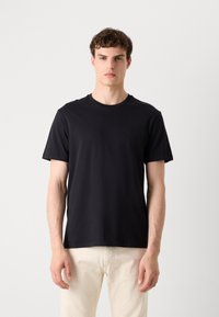 Black cotton t-shirt with a round neck and short sleeves. Features a small logo on the chest. Designed for a relaxed fit.