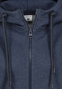 Navy blauwe zip-up hoodie met een gestructureerde stof, voorzien van een trekkoord capuchon en een contrasterende ritssluiting aan de voorkant. M maatlabel zichtbaar.