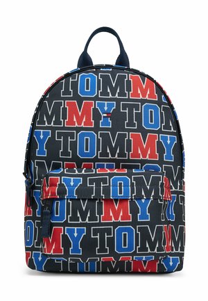 Zaino con testo ripetuto "TOMMY" in rosso, blu e bianco su tessuto nero, con tasca frontale con zip e maniglia superiore.