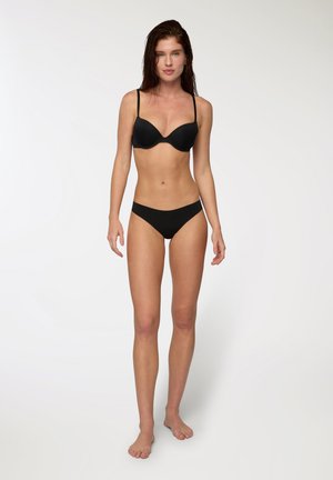 Set di bikini nero composto da un reggiseno con ferretto imbottito e spalline regolabili, abbinato a slip a vita bassa. Tessuto liscio con cuciture minime.