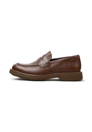 Brauner Leder-Slipper mit rundlicher Zehenpartie, niedrigem Absatz und einem Riemendetail über dem Spann, vor weißem Hintergrund.