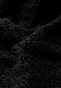 Czarna tkanina o teksturze z otwartym splotem, z miękką, lekko puszystą powierzchnią. Materiał wydaje się lekki i elastyczny.