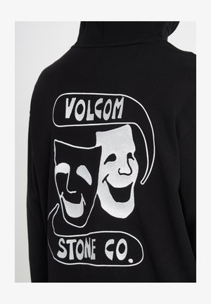Zwarte hoodie met witte theatrale komedie- en tragediemaskers en de tekst "Volcom Stone Co." op de achterkant.