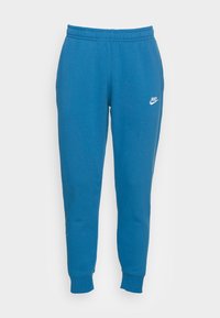 Blå Nike sweatpants i mjuk bomullsblandning, med elastisk midja, smalnade ben och en vit logotyp på vänster lår.