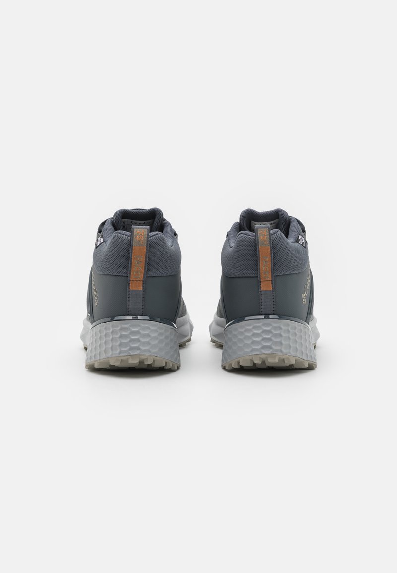 Scarpe da atletica di colore grigio scuro con tomaia in rete testurizzata, colletto imbottito e accenti arancioni a contrasto sul tallone e sul logo. Suola in gomma.