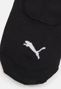 Crna anklet čarapa napravljena od mekanog materijala s bijelim Puma logotipom na prstima. Glatka tekstura s prilagođenim dizajnom za udobnost.