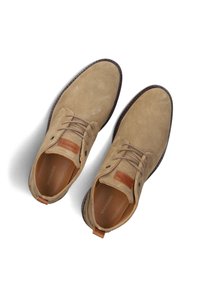 Chaussures en daim beige avec un design simple. Bout rond, lacets sur le devant et accent en cuir au niveau du talon. Semelles en caoutchouc avec des coutures contrastantes.