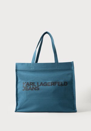 Niebieska torba materiałowa z dwoma uchwytami i czarnym tekstem "KARL LAGERFELD JEANS" nadrukowanym na przedniej stronie.