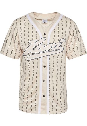 Maglietta da baseball a maniche corte beige con linee ondulate nere, bottoni frontali e un logo bianco prominente. Presenta un bordo bianco lungo il colletto.