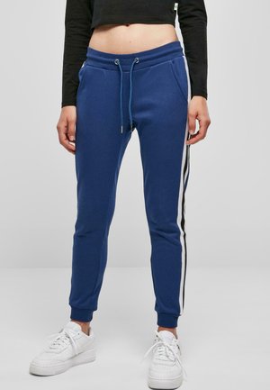 Blaue Jogginghosen mit einem Kordelzugbund, Seitentaschen und weißen sowie schwarzen Streifenakzenten entlang der äußeren Nähte. Aus weichem Stoff gefertigt.