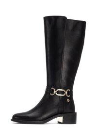 Botas de cuero negras hasta la rodilla con un acento de cadena dorada brillante y detalle de hebilla. Tacón apilado y textura suave.
