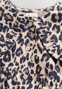 Robe à imprimé léopard avec col volanté, présentant des couleurs beige et marine, et de légers boutons sur le devant. Tissu à motif texturé.