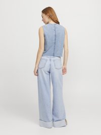 Top senza maniche in denim con taglio dritto e chiusura posteriore con bottoni, abbinato a jeans a gamba larga blu chiaro con risvolti e tasche.