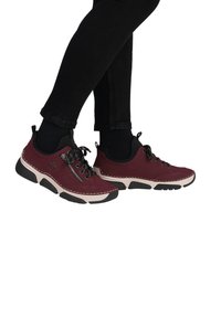 Baskets en suède bordeaux avec des accents noirs, des lacets texturés, un détail de fermeture éclair sur le côté et une semelle blanche contrastante.