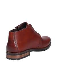 Bottine en cuir marron avec lacets noirs, talon en bois empilé et semelle en caoutchouc noir, montrée de l'angle arrière.
