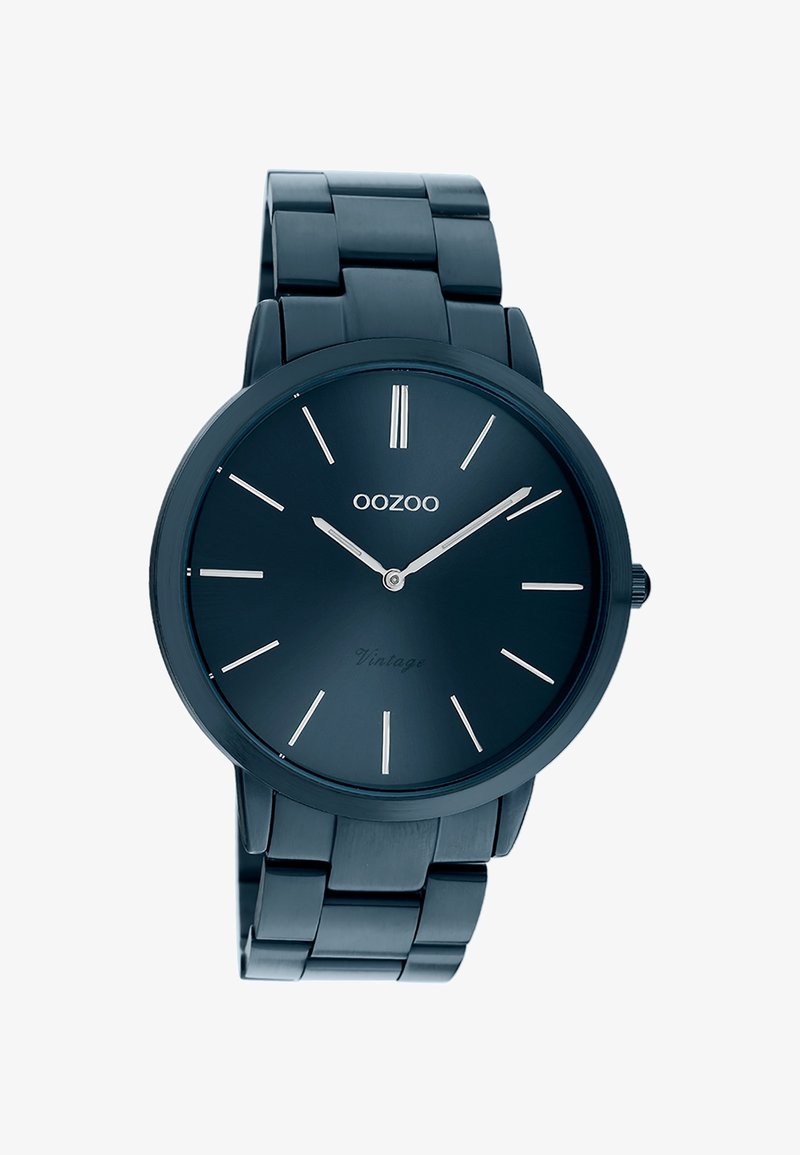 Montre-bracelet en métal bleu foncé avec cadran minimaliste, index argentés, et aiguilles des heures et des minutes argentées indiquant 10h10.