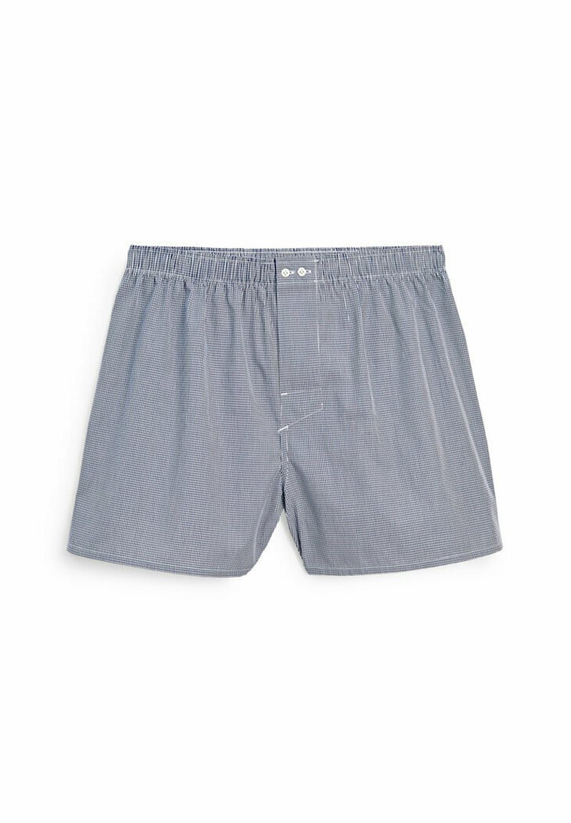 Boxers à carreaux bleus et blancs en coton doux. Dotés d'une taille élastique et de deux boutons à l'avant. Coupe décontractée avec fentes latérales.
