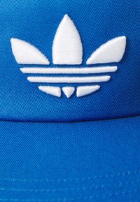 Boné de baseball azul com um logótipo adidas trefoil branco bordado. Apresenta riscas horizontais por baixo do logótipo. Feito de tecido texturizado.