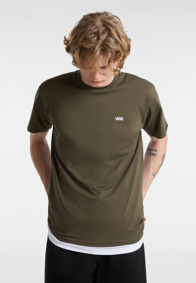 Camiseta de manga corta verde oliva hecha de tela suave, con un pequeño logo blanco de Vans en el lado izquierdo del pecho y un cuello redondeado.