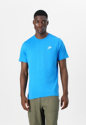 Modra bombažna majica s kratkimi rokavi in okroglim ovratnikom, z belim logotipom Nike na levem prsnem delu. Gladka tekstura, standardna prileganje.