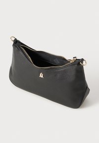 Borsa nera in pelle con zip e superficie testurizzata, caratterizzata da un accento del logo in tonalità dorata e un interno liscio. Due anelli di attacco.