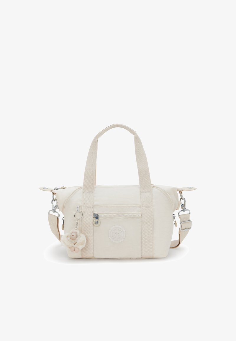 Sac à main en tissu beige avec des poignées doubles et une bandoulière amovible. Présente une poche zippée à l'avant et un charme en forme d'ours en peluche. Détail logo rond visible.