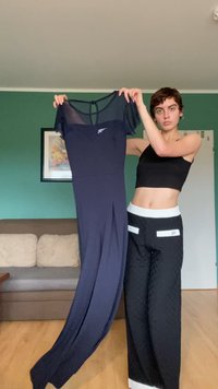 Jūras zilas sporta kleitas ar īsām caurspīdīgām piedurknēm, apaļš kakla izgriezums un smalks logotips uz krūtīm. Garš, plūstošs svārks.