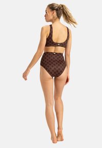 Hnedý bikiny set s kvetinovým vzorom. Horná časť má široké ramienka a zaoblený chrbát, zatiaľ čo spodná časť s vysokým pásom má bezšvový dizajn.