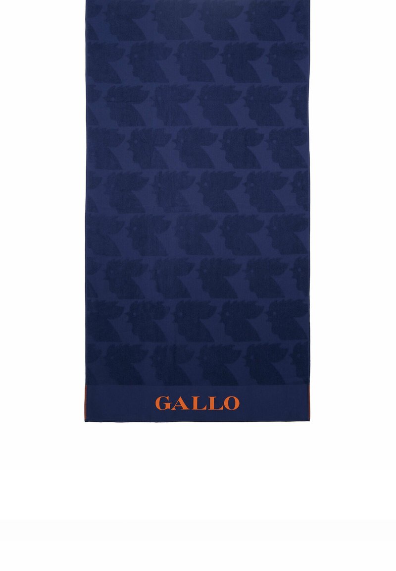 Asciugamano blu navy con un motivo in rilievo di volti stilizzati. Nella parte inferiore si trova un logo arancione "GALLO". Texture morbida, forma rettangolare.