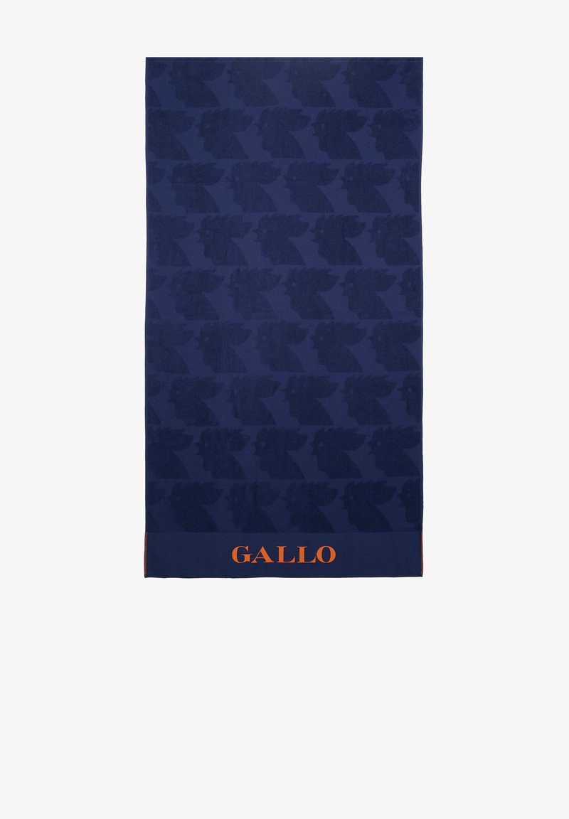 Asciugamano blu navy con un motivo in rilievo di volti stilizzati. Nella parte inferiore si trova un logo arancione "GALLO". Texture morbida, forma rettangolare.