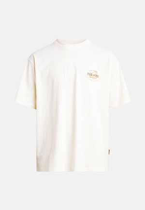 Camiseta de algodón color crema con mangas cortas y cuello redondo. Tiene un diseño circular impreso en el pecho en tonos dorados.