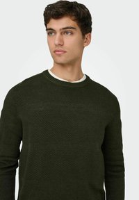 Suéter verde de punto con un diseño texturizado y rayas horizontales. Cuello y puños acanalados, diseñado para un ajuste ceñido.