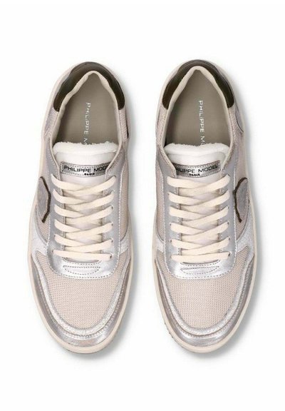 Baskets avec une tige en mesh beige, accents argentés et lacets crème. Bout arrondi, semelle plate et patch logo sur le côté. Détails en tissu texturé.