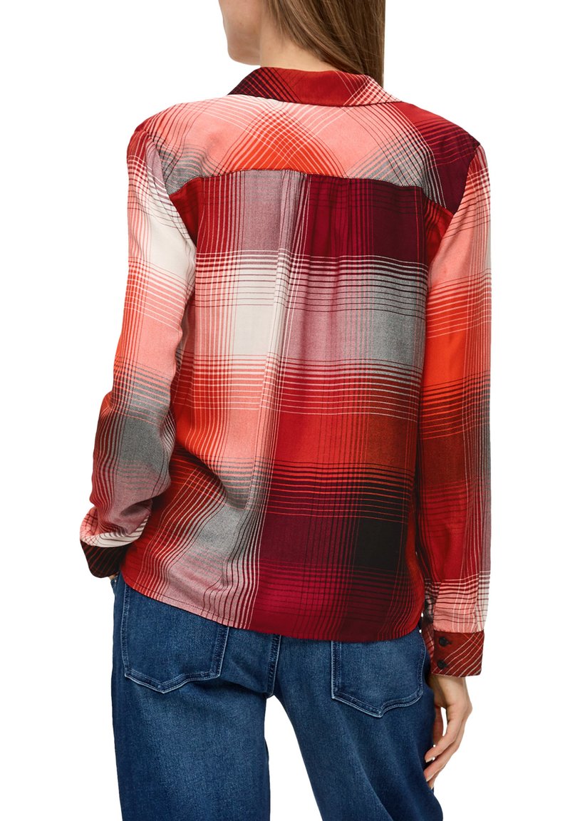 Camicia a quadri rossa e arancione con maniche lunghe, colletto e polsini con bottoni. Presenta modelli a scacchi a contrasto chiaro e scuro. Tessuto morbido e leggero.