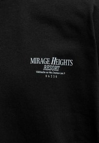 Μαύρο ύφασμα με λευκό κείμενο που γράφει "MIRAGE HEIGHTS RESORT, Villefranche-sur-Mer, Crestview Lane, 9, 06230" στο κέντρο.