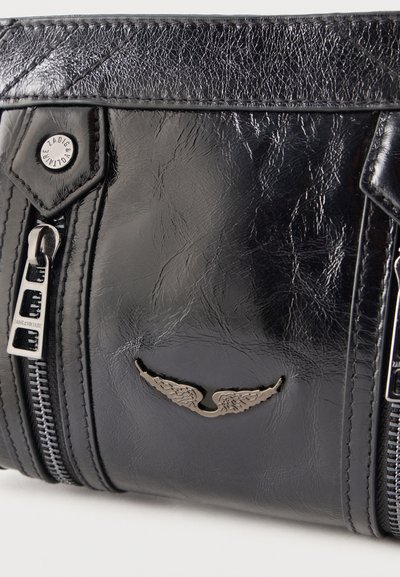 Μαύρο τμηματικό δερμάτινο σακίδιο με υφή, με ασημένιο έμβλημα φτερού, ορατά φερμουάρ και μεταλλικό κουμπί και τράβηγμα φερμουάρ με λογότυπο.