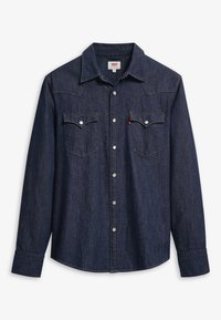 Donkerblauwe spijkerblouse met lange mouwen, puntkraag, twee borstzakken, witte stiksels en zilveren drukknoopjes.