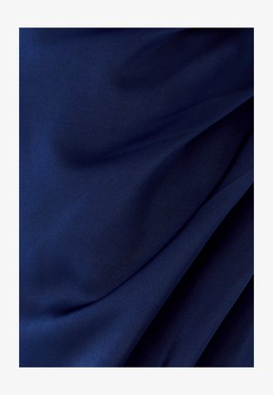 Ciemnoniebieska tkanina z miękkimi fałdami i gładką teksturą, ukazująca delikatne drapowania i subtelne odbicia światła.