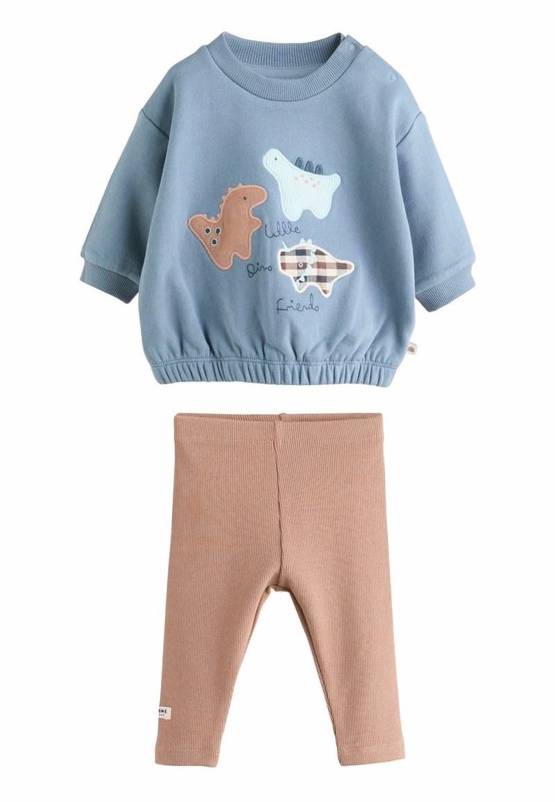 Niebieska bluza z aplikacjami dinozaurów, elastycznym pasem i ściągaczami, zestawiona z beżowymi, prążkowanymi legginsami. Miękka tkanina bawełniana.
