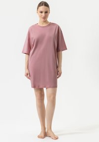 Abito over-size a maniche corte in morbido tessuto rosa. Design semplice e dritto con scollatura rotonda e lunghezza fino a metà coscia.