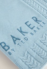 Šviesiai mėlyna megzta medžiaga su pakeltomis, tekstūruotomis kabelių raštais. Žymiai išsiuvinėtas "BAKER by TED BAKER" tamsesnėje mėlynoje spalvoje.